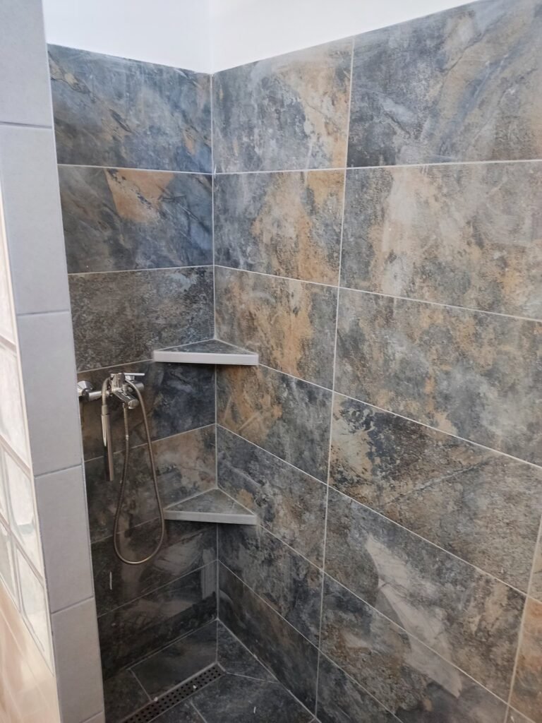 Ντους με πολύχρωμα πλακίδια και γωνιακά ράφια